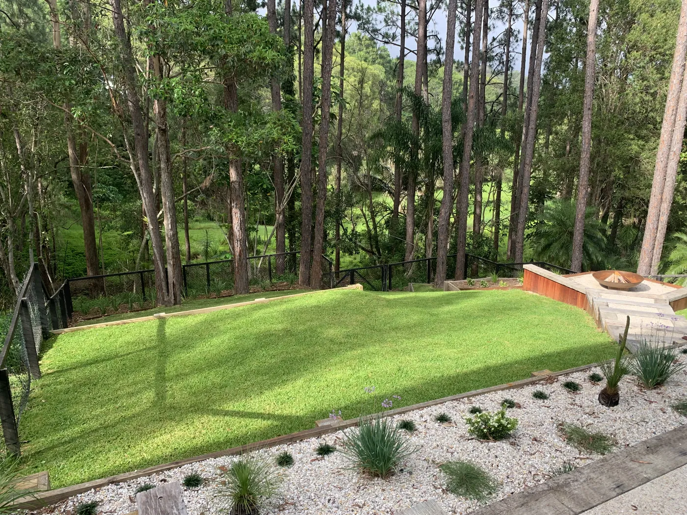 Bushland backyard lawn with a fire pit and gravel bed