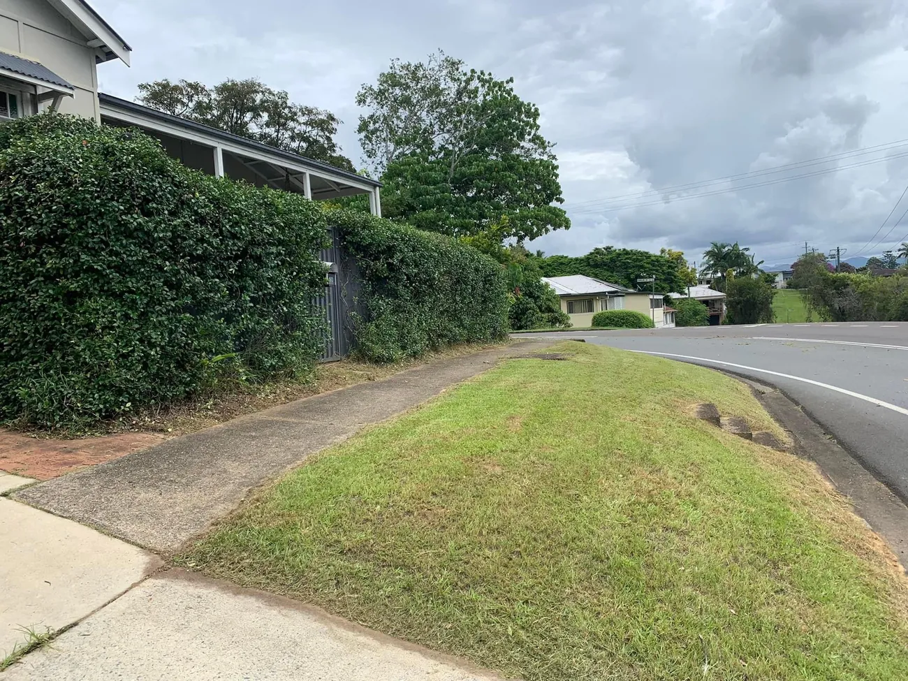 Trimmed hedge and mowed nature strip by the road